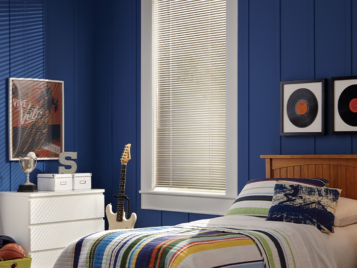 Modern Precious Metals® Aluminum Blinds cover a window in a kid’s bedroom.